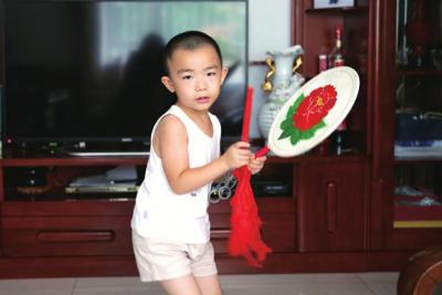 最小的队员王禹宸在练习太平鼓