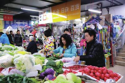 李文勇夫妇在小区门口的菜市场采购