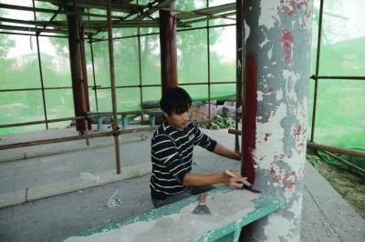 石门营幸福公园幸福亭内，工人们正在粉刷支柱